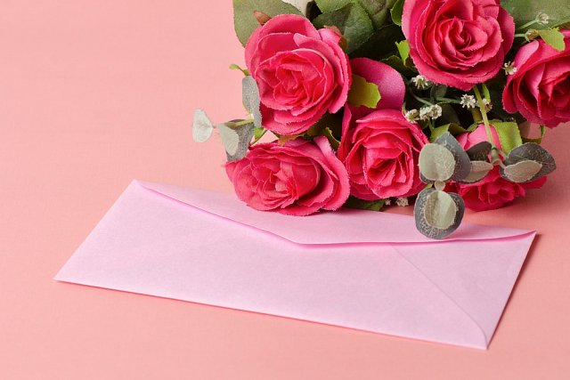 zaproszenia ślubne w różowej kopercie i kwiaty